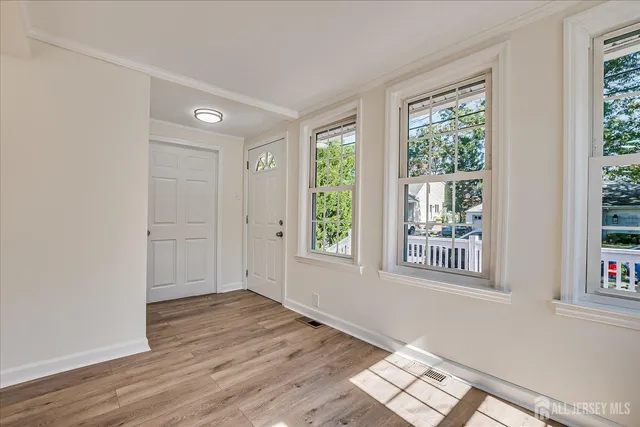 a kitchen with stainless steel appliances granite countertop a refrigerator a sink dishwasher a stove top oven a refrigerator with white cabinets and wooden floor