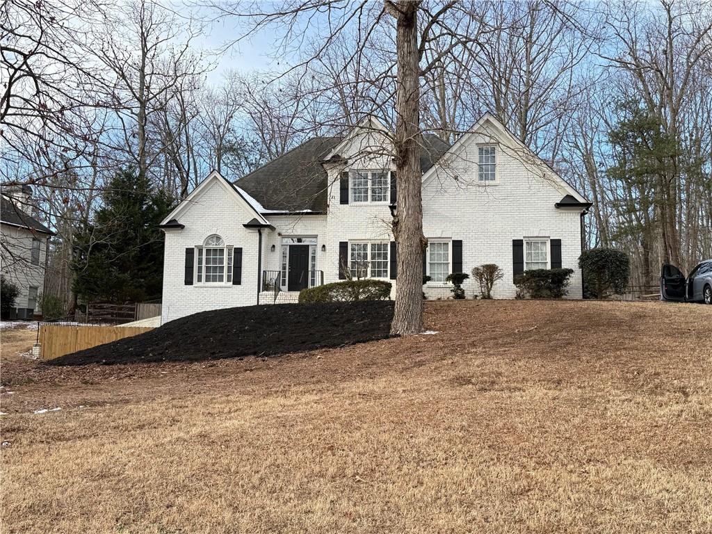 3860 Pinewood Court Cumming, GA 30041 - Photo 1 of 1 a view of a white house with a yard covered in snow