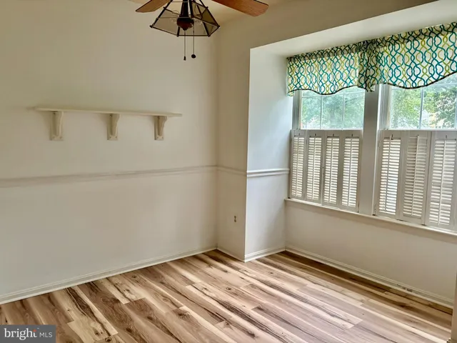 a view of a bedroom with wooden floor and windows