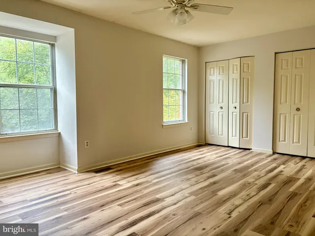 a view of a bedroom with wooden floor and bathroom