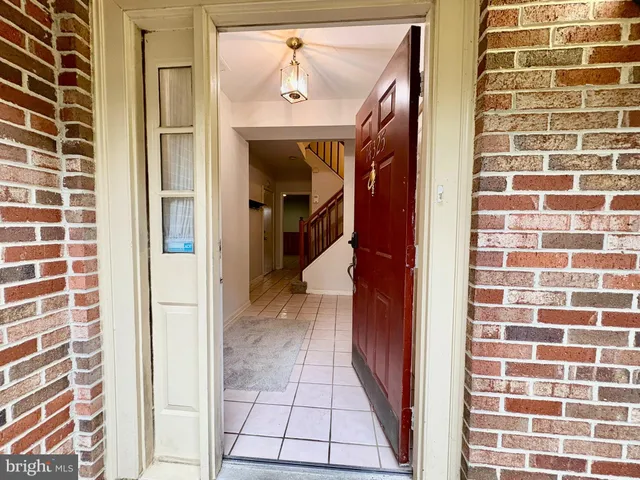 a view of staircase with lots of frames on wall and a chandelier