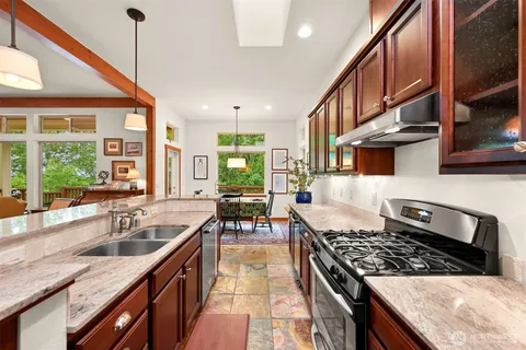 a kitchen with stainless steel appliances granite countertop a sink stove and cabinets