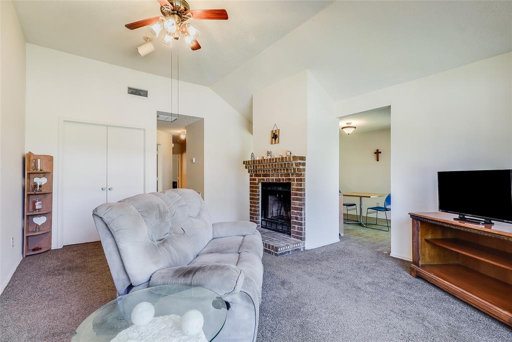 1728 Hackamore Street Mesquite, TX 75149 - Photo 6 of 22 Carpeted living area featuring lofted ceiling, a brick fireplace, and ceiling fan
