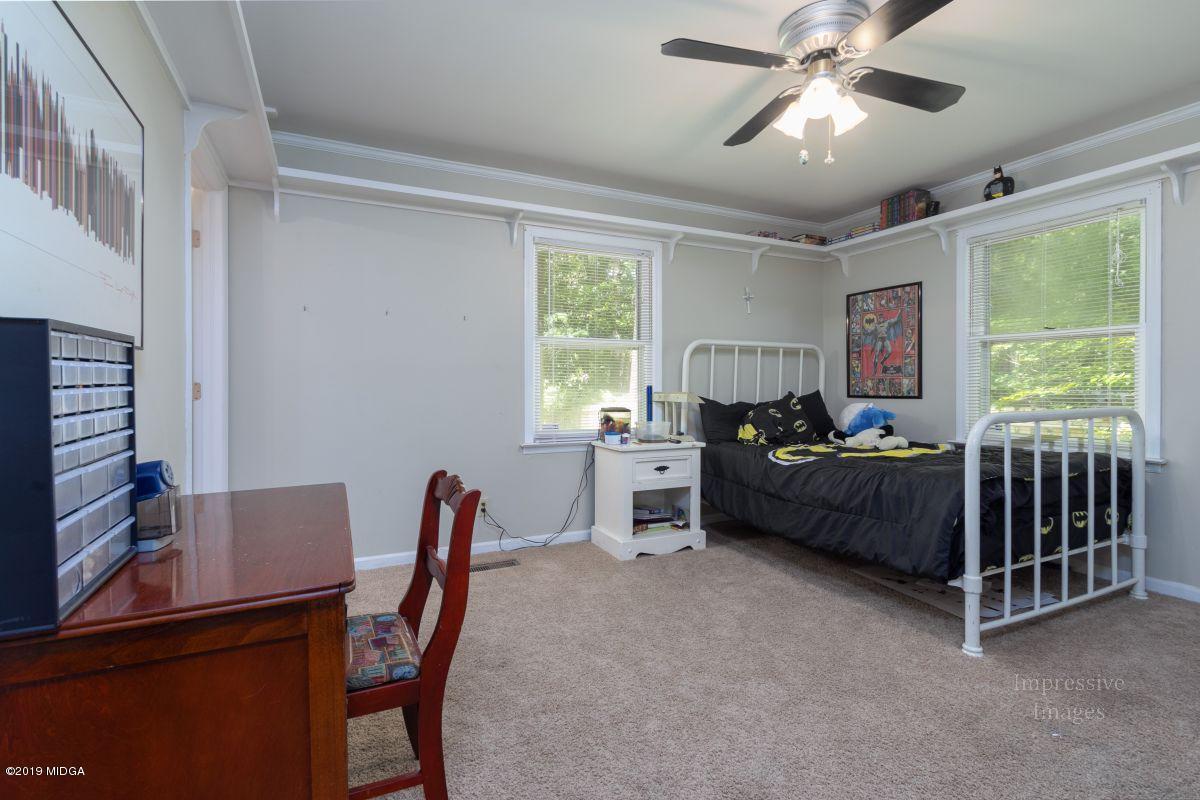 180 Castlegate Road Macon, GA 31210 - Photo 16 of 23 a bedroom with a bed and a chandelier