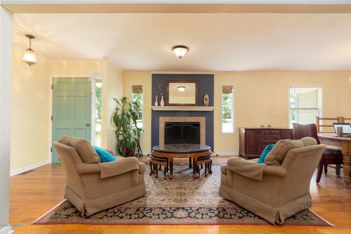 180 Castlegate Road Macon, GA 31210 - Photo 6 of 23 a living room with furniture a large window and a fireplace