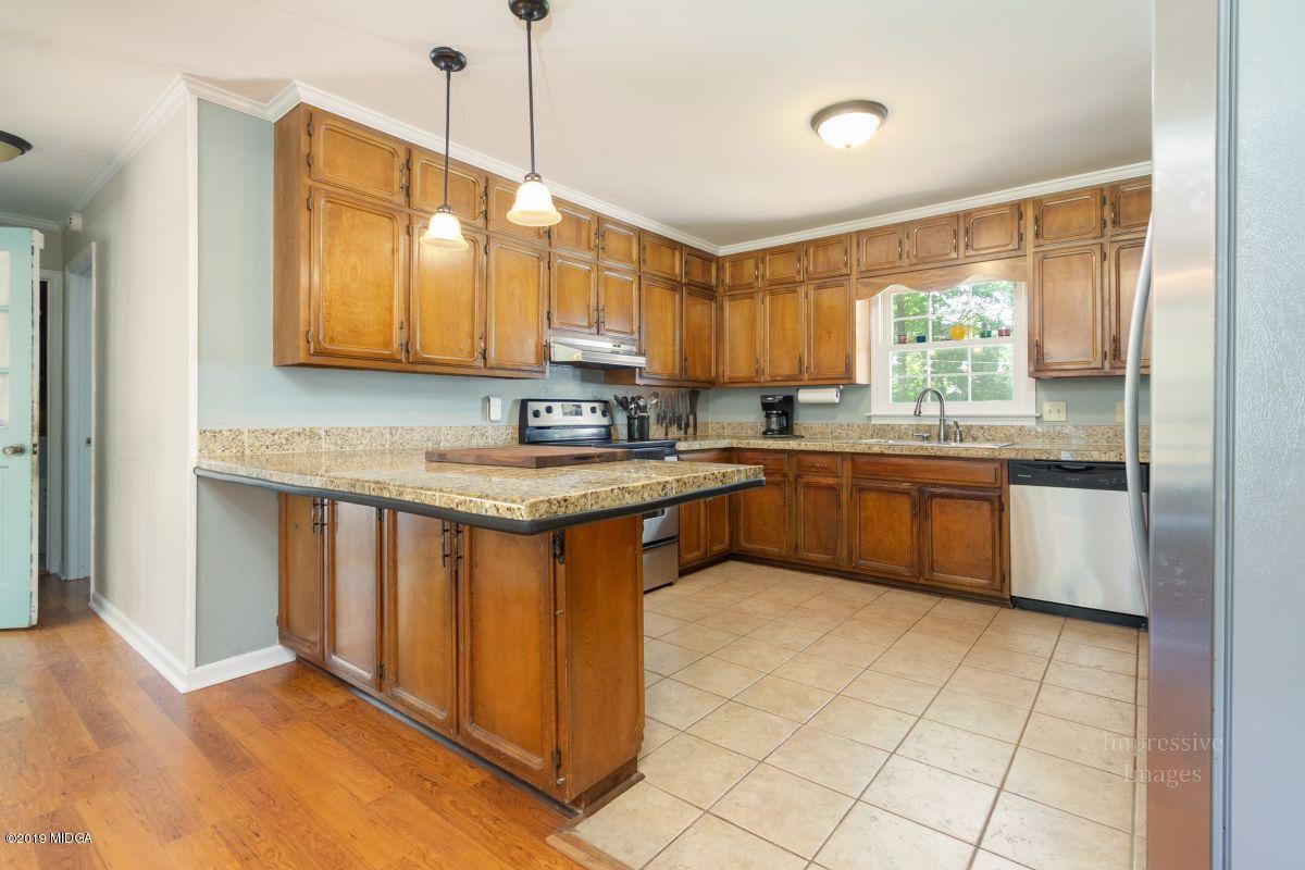 180 Castlegate Road Macon, GA 31210 - Photo 9 of 23 a kitchen with stainless steel appliances granite countertop a sink a stove and a refrigerator