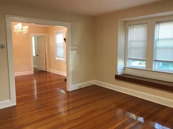 a view of a room with wooden floor and window