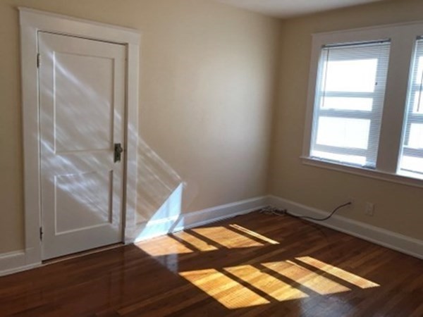 139 Pine Street, Unit 1/F Quincy, MA 02170 - Photo 9 of 10 an empty room with wooden floor and windows