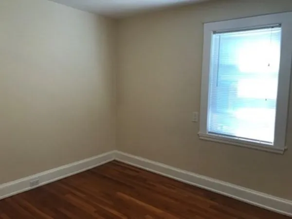 a view of a small space with wooden floor and a window