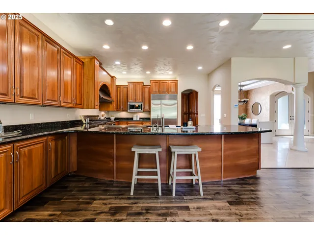 a kitchen with stainless steel appliances granite countertop a stove a sink and a microwave