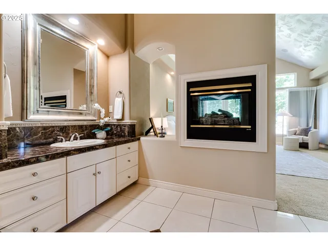 a bathroom with a sink a mirror and a view of living room