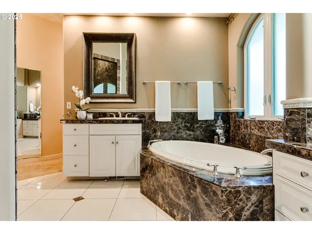 a bathroom with a tub sink and mirror