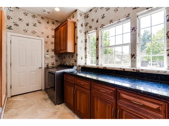 a kitchen with stainless steel appliances kitchen island granite countertop a refrigerator and a sink