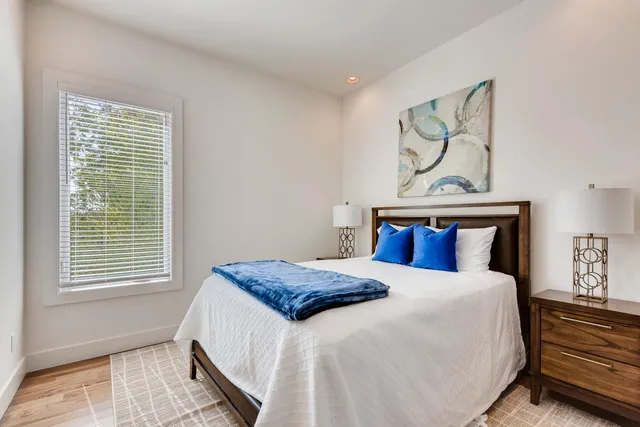 a bedroom with a bed and painting on the wall