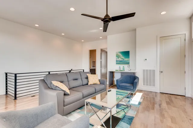 a living room with furniture and a wooden floor