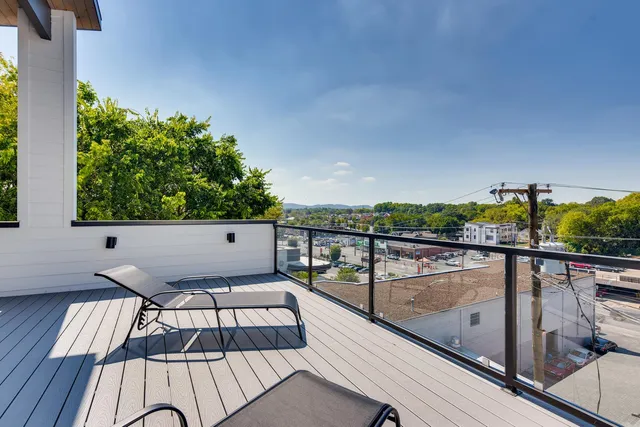 a view of a balcony with wooden floor and iron fence