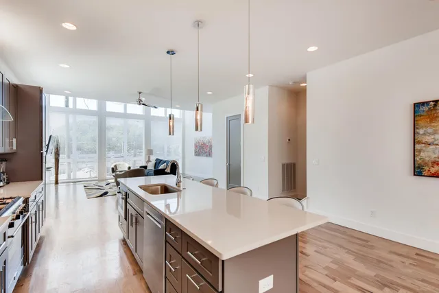 a kitchen with stainless steel appliances granite countertop a sink a stove and a refrigerator