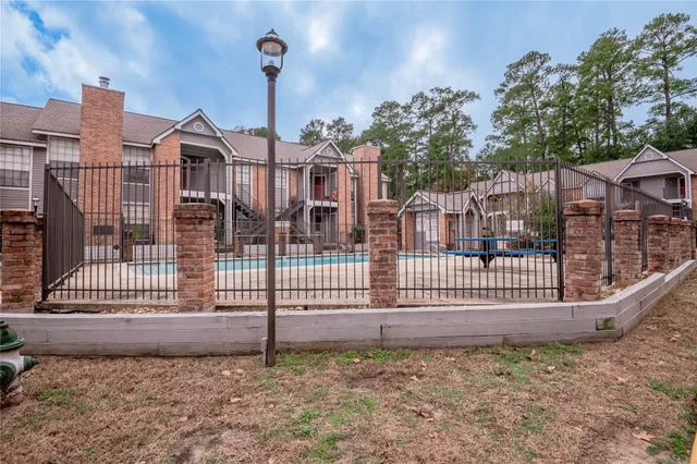 a view of a brick house with wooden fence
