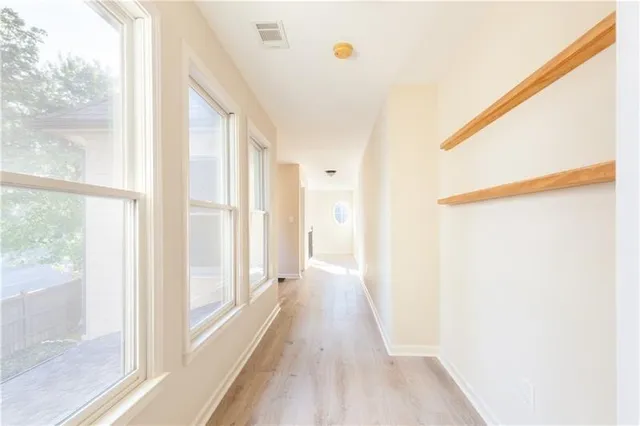 a view of a big room with chandelier fan and windows