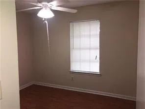 an empty room with a window and a chandelier fan