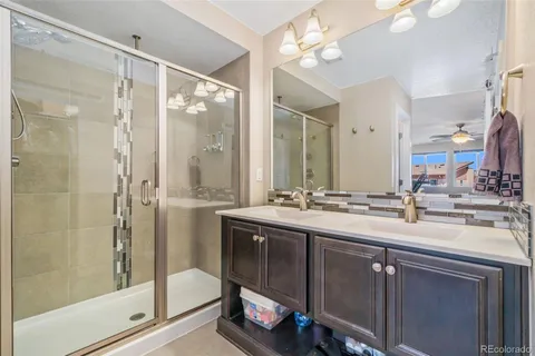 a bathroom with a double vanity sink mirror and shower