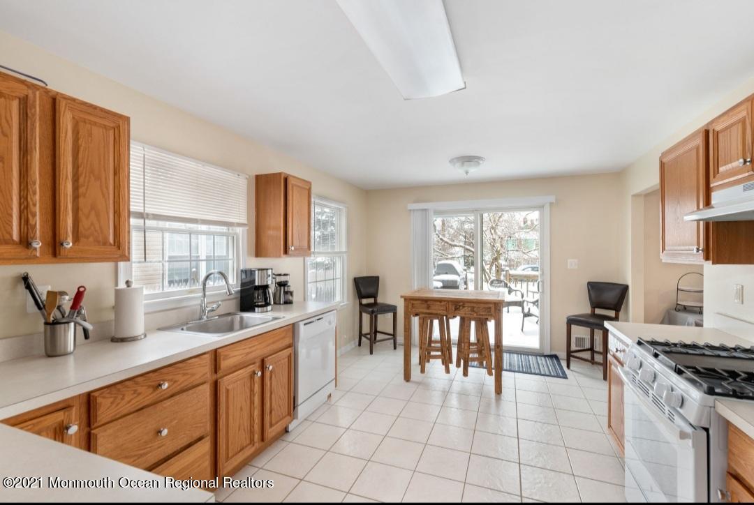 298 Spring Street Red Bank, NJ 07701 - Photo 8 of 17 a large kitchen with stainless steel appliances a stove a sink a dining table and chair