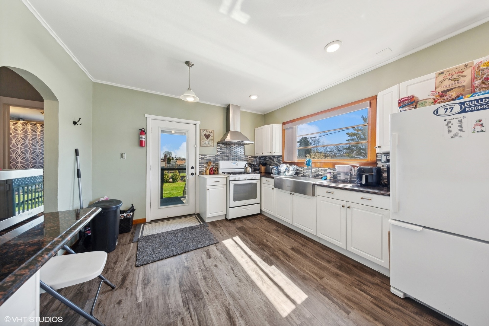 8715 44th Place Lyons, IL 60534 - Photo 4 of 28 a kitchen with stainless steel appliances a stove a sink dishwasher a refrigerator white cabinets with wooden floor