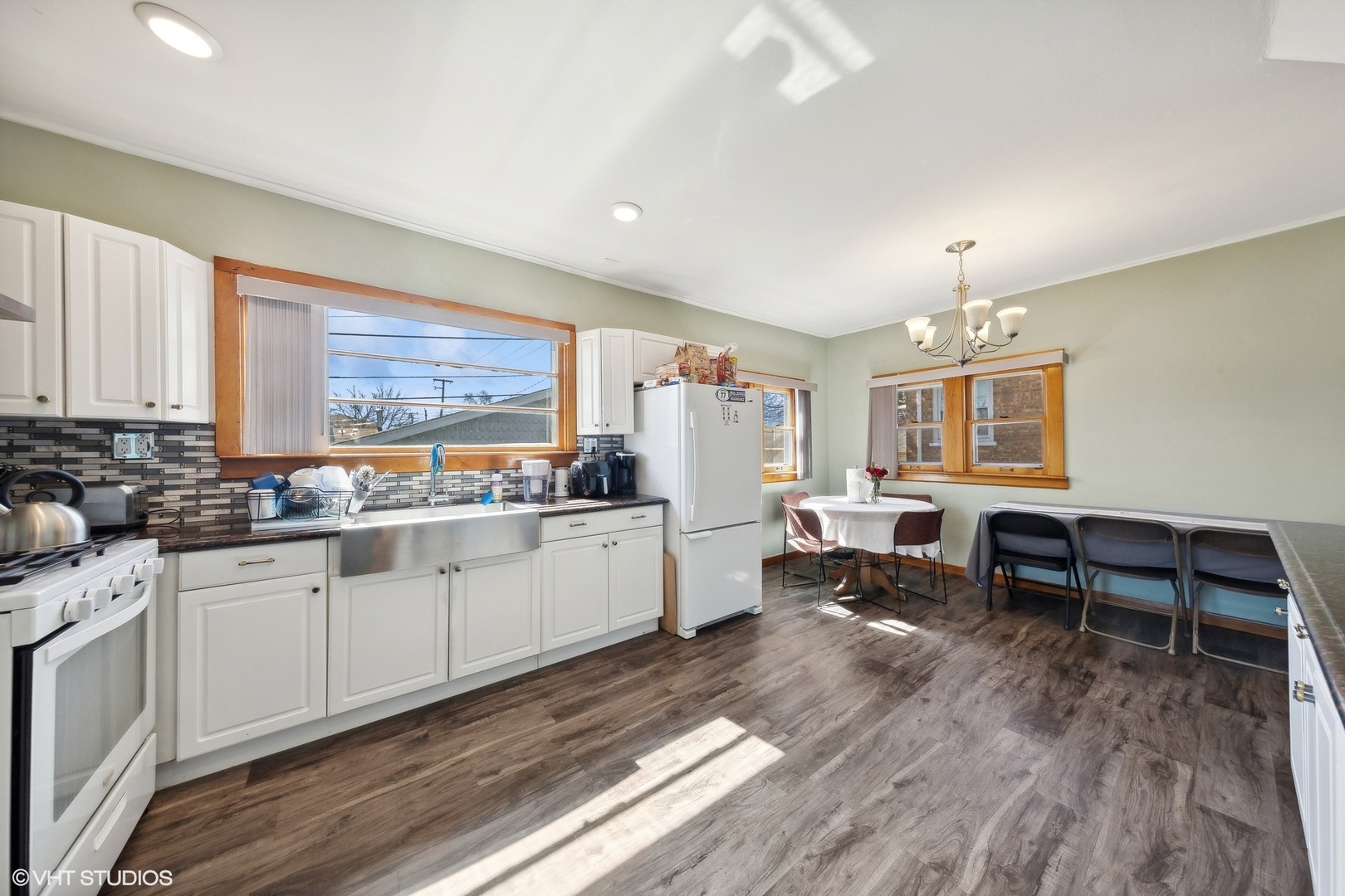 8715 44th Place Lyons, IL 60534 - Photo 6 of 28 a large white kitchen with wooden floor and stainless steel appliances