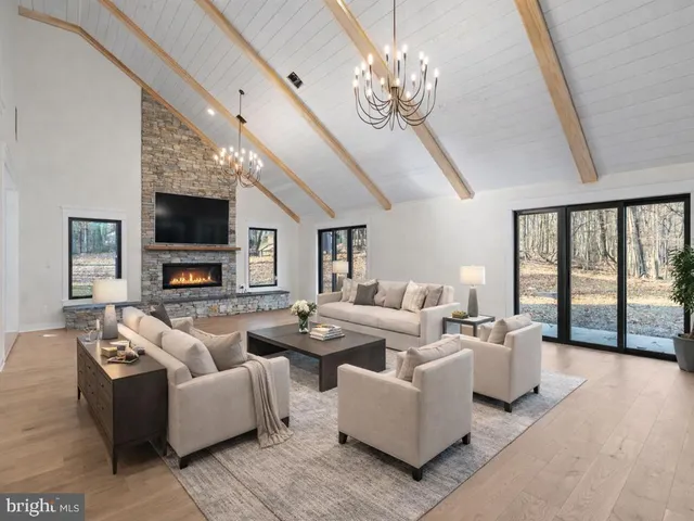 a living room with furniture chandelier and a flat screen tv