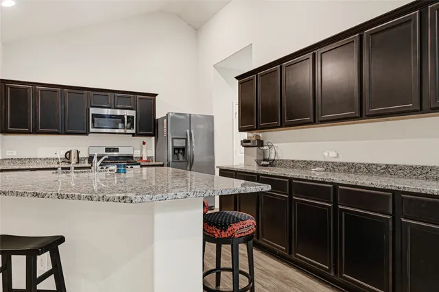 a kitchen with stainless steel appliances granite countertop a stove a sink and a microwave