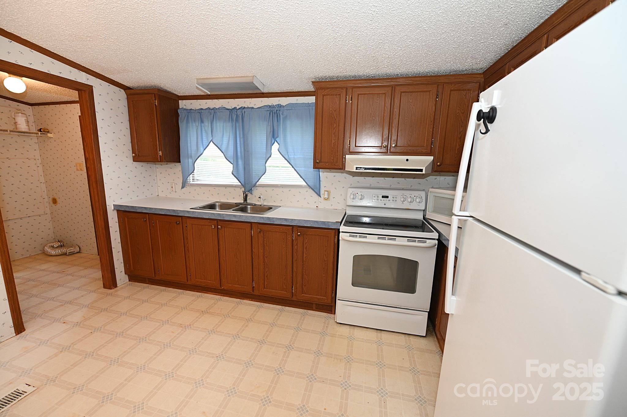 4171 Leatherman Road Vale, NC 28168 - Photo 17 of 24 a kitchen with granite countertop a refrigerator and a stove top oven