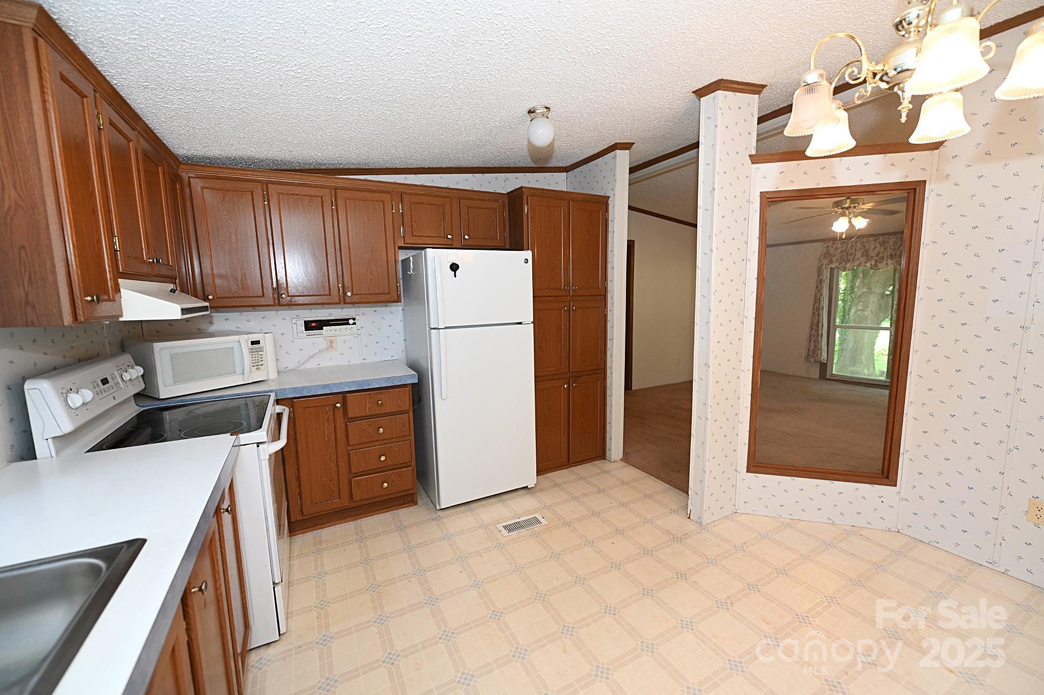 4171 Leatherman Road Vale, NC 28168 - Photo 19 of 24 a kitchen with a refrigerator a stove top oven and cabinets