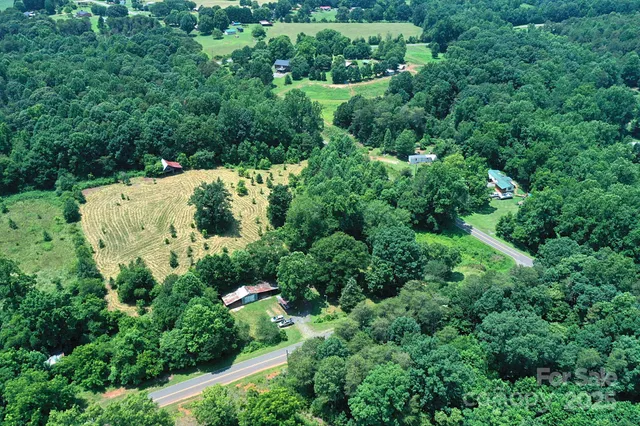 an aerial view of residential house with outdoor space and trees all around