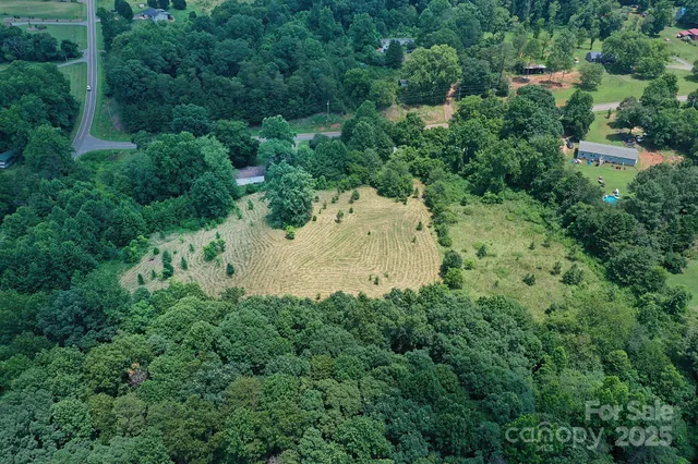 an aerial view of residential house with outdoor space and trees all around