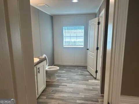 a bathroom with a granite countertop sink toilet and mirror
