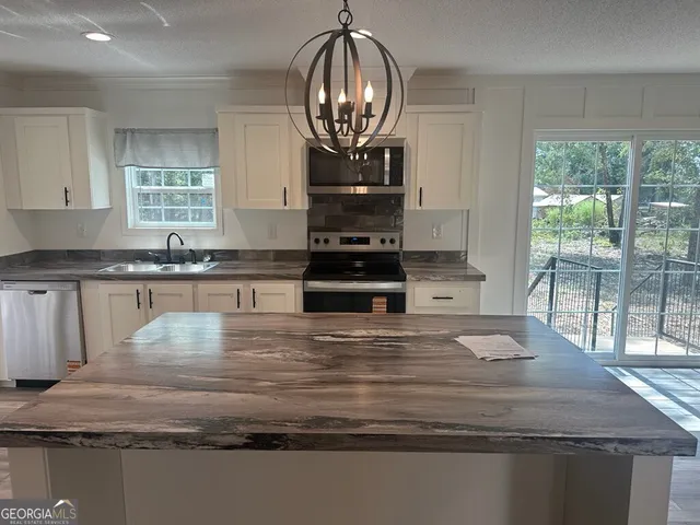 a kitchen with stainless steel appliances granite countertop a refrigerator and a sink