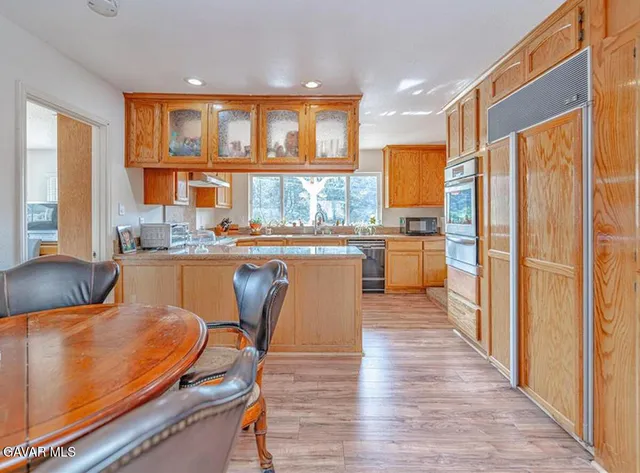 a kitchen with stainless steel appliances granite countertop a refrigerator and wooden cabinets