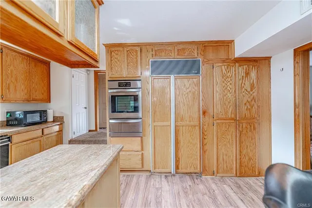 a kitchen with stainless steel appliances a refrigerator and wooden cabinets