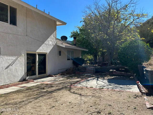 a view of a house with backyard and sitting area