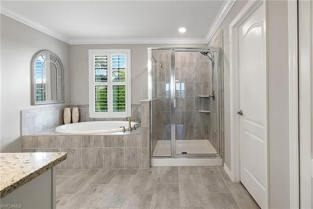 a spacious bathroom with a granite countertop sink a large mirror a bathtub and next to a window