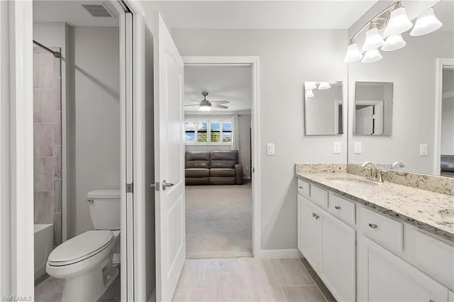 a white toilet sitting next to a white bath tub