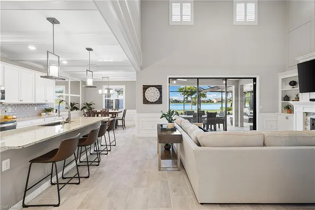 a living room with furniture a large window and wooden floor