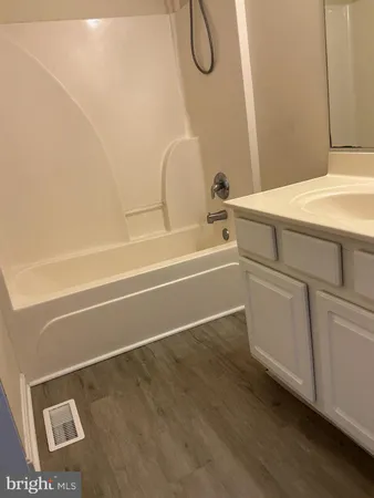 a view of a hallway with wooden floor and a door