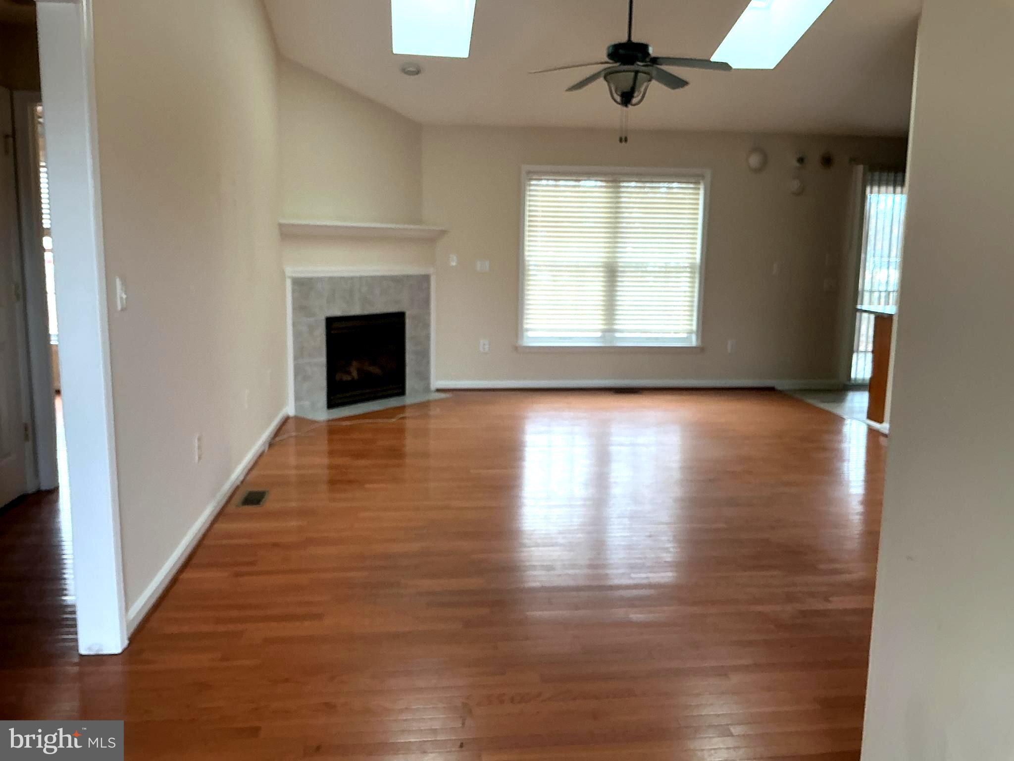 205 Freedom Road Locust Grove, VA 22508 - Photo 4 of 29 an empty room with wooden floor fireplace and windows