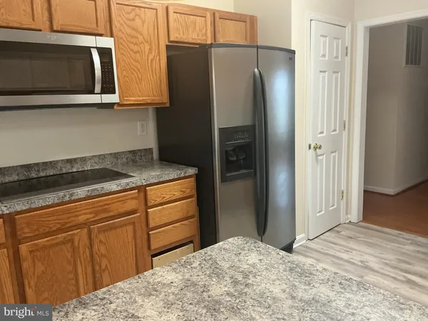a kitchen with granite countertop a sink a stove and cabinets