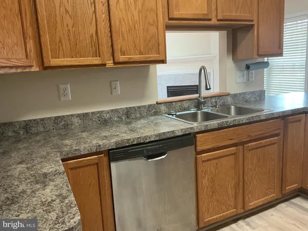 a kitchen with granite countertop wooden cabinets and a stove top oven