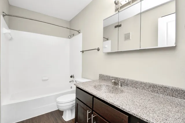 an empty room with closet and a ceiling fan