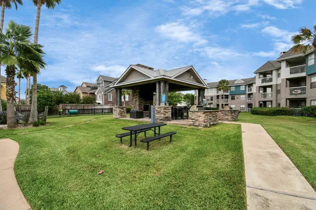 a view of a roof deck with table and chairs with wooden floor and fence
