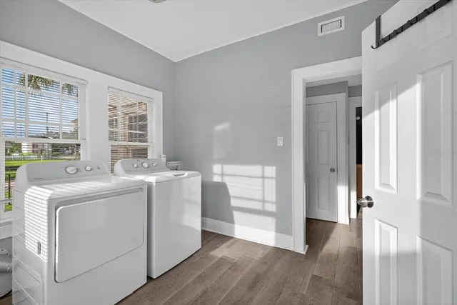 a view of a room with wooden floor cabinet and front door
