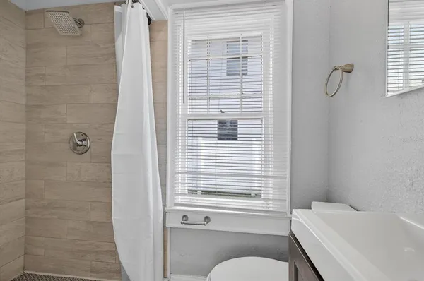 a bathroom with a sink a toilet and a window